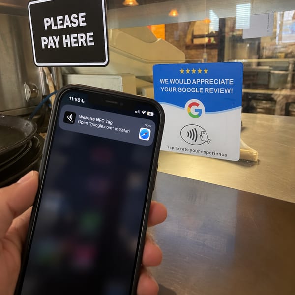 A customer holds a phone up to the Google review card at the counter, and a prompt to open the review page appears on screen.